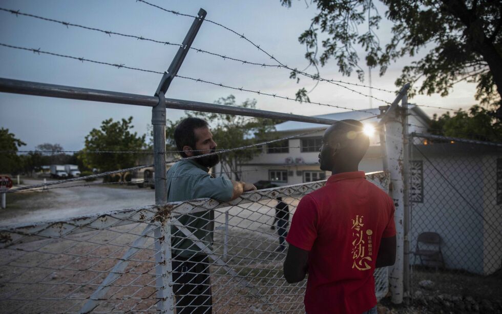 To ansatte snakker sammen ved hovedkvarteret til Christian Aid Ministries i byen Titanyen, nord for Port-au-Prince i Haiti. Nå er alle de 17 nordamerikanske misjonærene som var bortført, satt fri.
 Foto:  Odelyn Joseph / NTB / AP
