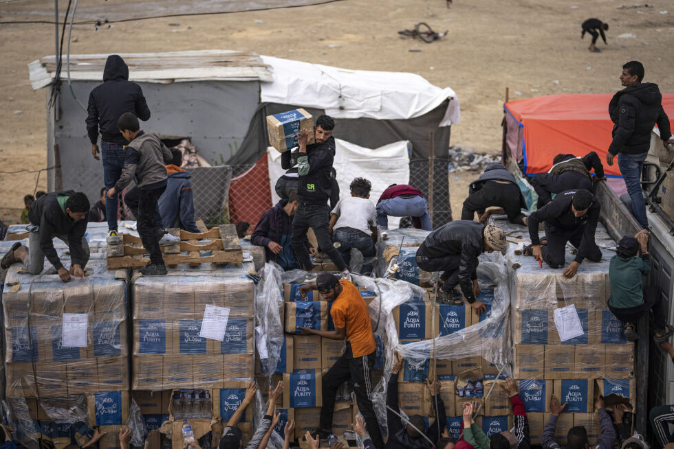 Ill.foto: Mennesker henter humanitær hjelp fra en lastebil som krysser inn på Gazastripen i Rafah.
 Foto: AP Photo/Fatima Shbair, File/NTB