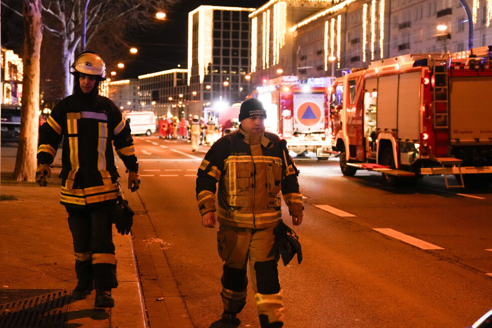 To brannmenn går gjennom et avsperret område nær et julemarked, etter at en bil kjørte inn i en folkemengde i Magdeburg, Tyskland, lørdag 21. desember 2024.
 Foto: AP Photo/Ebrahim Noroozi/NTB