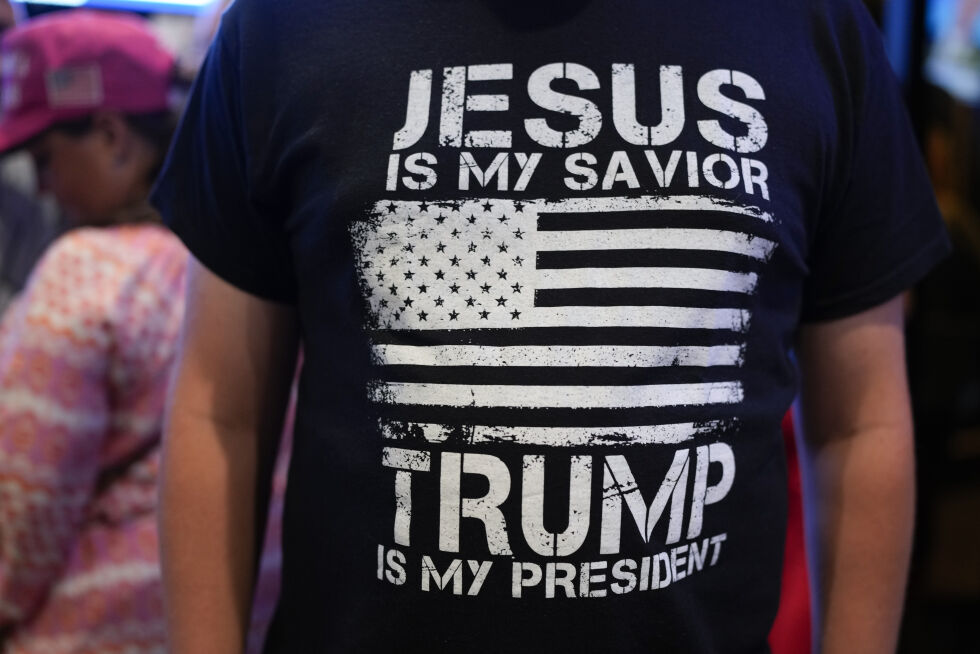 En Trump-supporter viser fram T-skjorten sin med teksten: «Jesus er min frelser. Trump er min president.»
 Foto: NTB / AP / George Walker IV