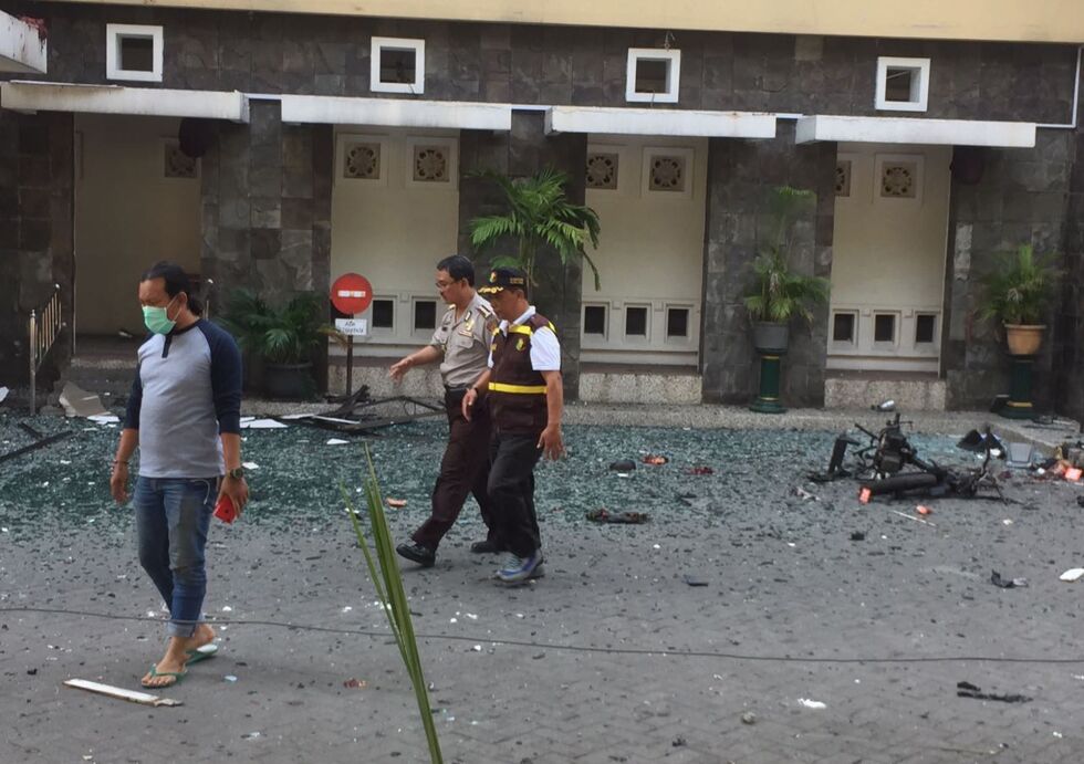 Knust glass ligger strødd på gaten utenfor Santa Maria-kirken i Surabaya, en av flere kirker som søndag morgen ble angrepet av selvmordsbombere. Foto: Trisnadi / AP / NTB scanpix