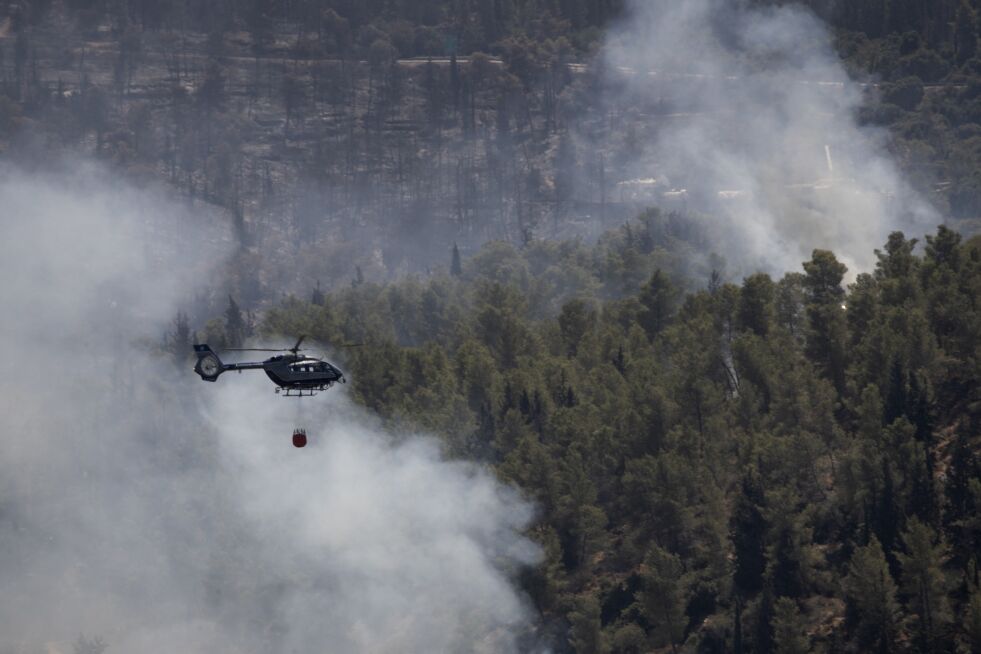Et israelsk brannhelikopter dumper tusenvis av liter med vann på en skogbrann vest for Jerusalem.
 Foto: Maya Alleruzzo / AP / NTB