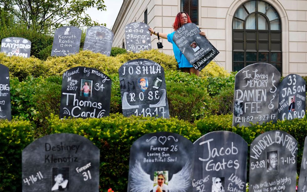 Jayde Newton hjelper til med å sette opp pappgravsteiner med navn på ofre for opioidmisbruk under en demonstrasjon mot OxyContin-produsenten Purdue Pharma i New York, 9. august 2021.
 Foto: AP Photo/Seth Wenig