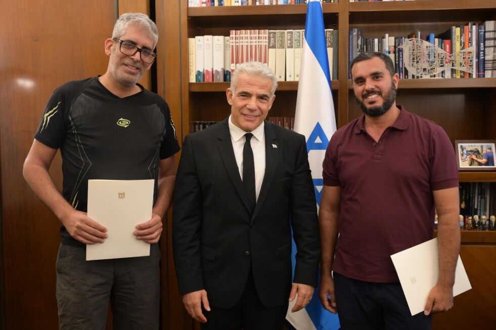 Statsminister Yair Lapid takket Haim Naim (t.h.) og Meshi Ben Ami (t.v.) for å ha vist handlekraft og mot under terrorangrepet på tirsdag.
 Foto: Amos Ben-Gershom (GPO)
