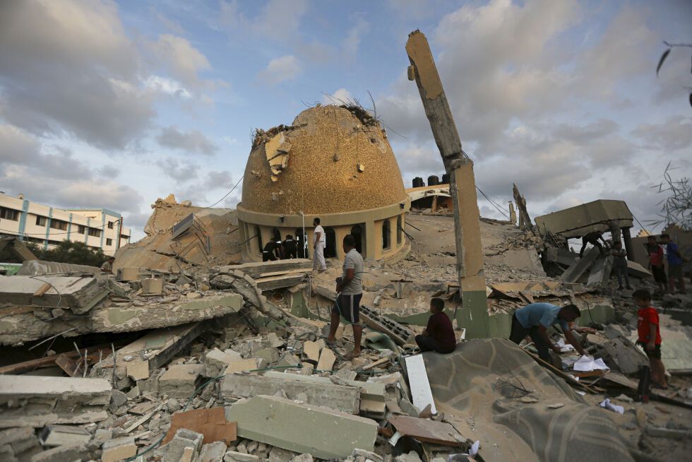 Palestinere utenfor en moské som er ødelagt etter et israelsk luftangrep mot Khan Younis på Gazastripen, søndag 8. oktober 2023.
 Foto: Foto: AP Photo/Yousef Masoud, arkiv/NTB.