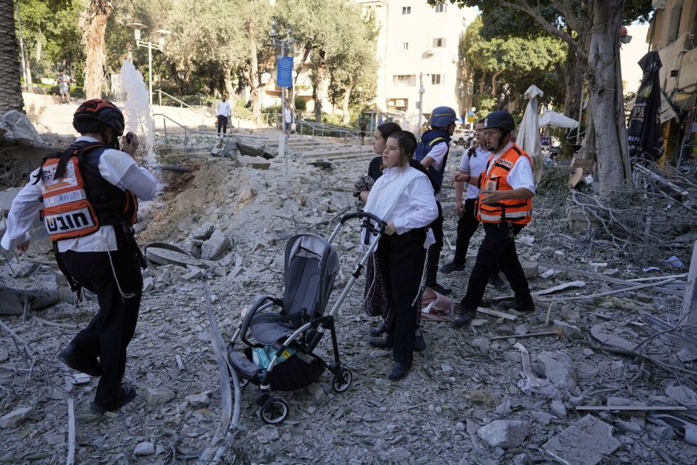 Redningsarbeidere evakuerer beboere fra et område i Haifa.
 Foto: Baz Ratner / AP / NTB