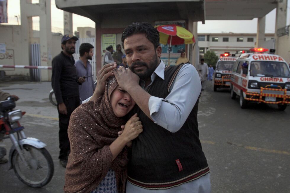 En mann trøster en kvinne som mistet sin ektemann under skyting mot kristne i Quetta søndag. Foto: Arshad Butt/AP/NTB scanpix
