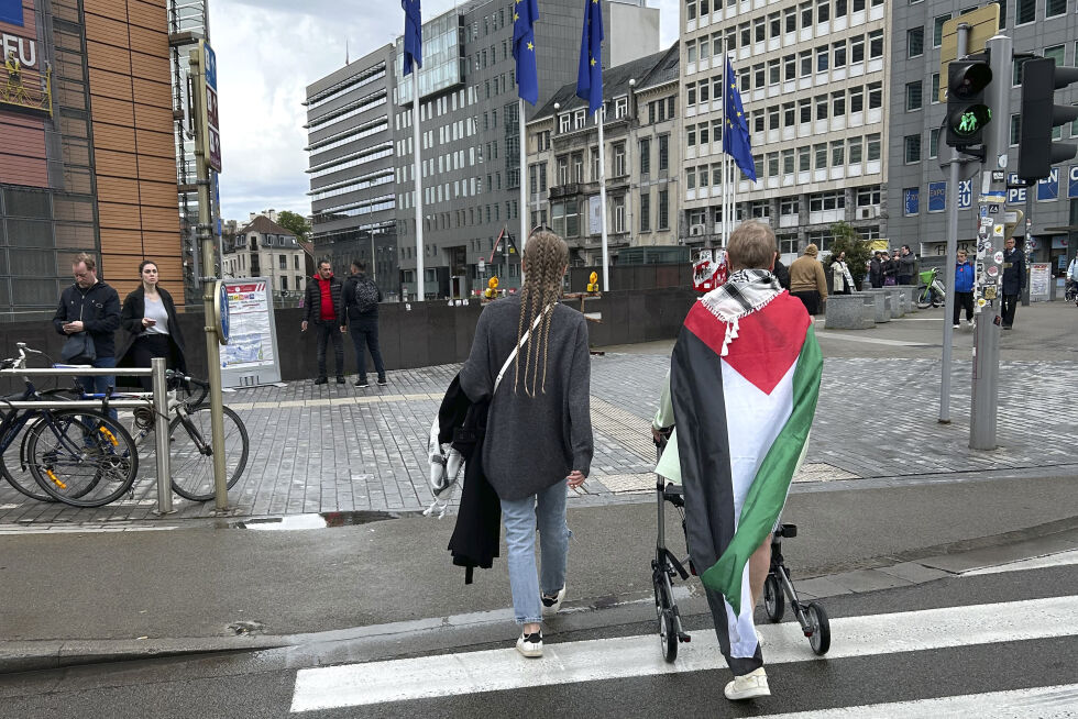 En kvinne går med palestinaflagg utenfor EU-hovedkvarteret i Brussel.
 Foto: NTB/AP