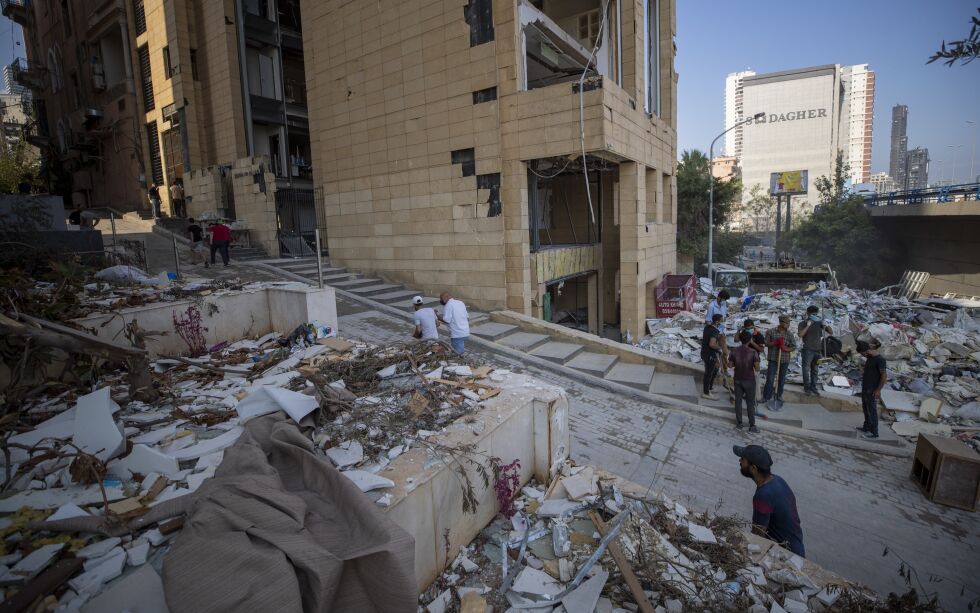 Arbeidere rydder opp etter eksplosjonen i forrige uke. Samtidig sprer konspirasjonsteorier og falske nyheter seg i sosiale medier om at det er Israel som stod bak.
Foto: Hassan Ammar / NTB Scanpix