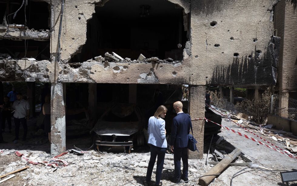 Forbipasserende i den israelske byen Petah Tikva ser på en utbrent bygning som er blitt rammet av en rakett fra Gaza. Nå brer det seg en gryende optimisme om at våpenhvilen skal holde og livet være normalt igjen.
 Foto: AP / NTB