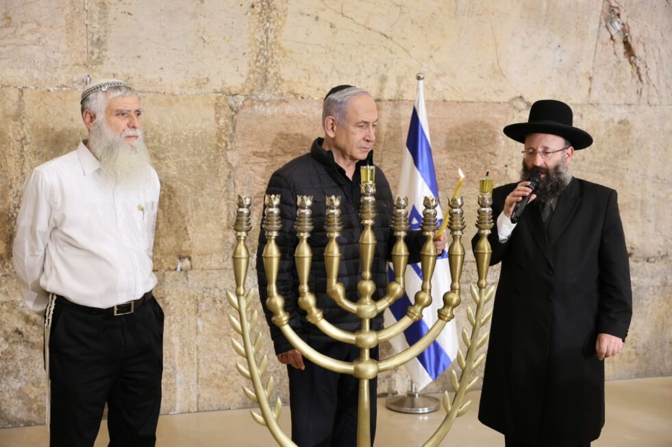 Israels statsminister Benjamin Netanyahu tenner det første lyset i Hanukka-lysestaken i tunellene under Vestmuren i Jerusalems gamleby, torsdag 7. desember 2023.
 Foto: Western Wall Heritage Center.
