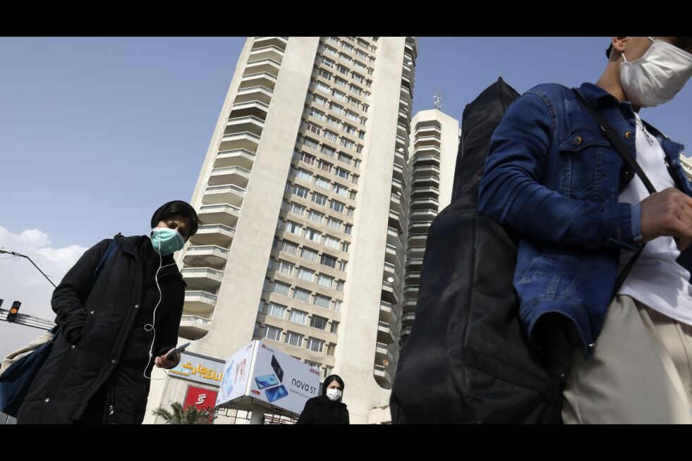 Fotgjengere med ansiktsmasker krysser en gate i Nord-Teheran søndag 1. mars 2020. Mens det nye koronaviruset har utvidet rekkevidden over hele verden, dukket det opp geografiske klynger av infeksjoner, der Iran, Italia og Sør-Korea fikk økende tilfeller.
 Foto: Vahid Salemi/NTB Scanpix