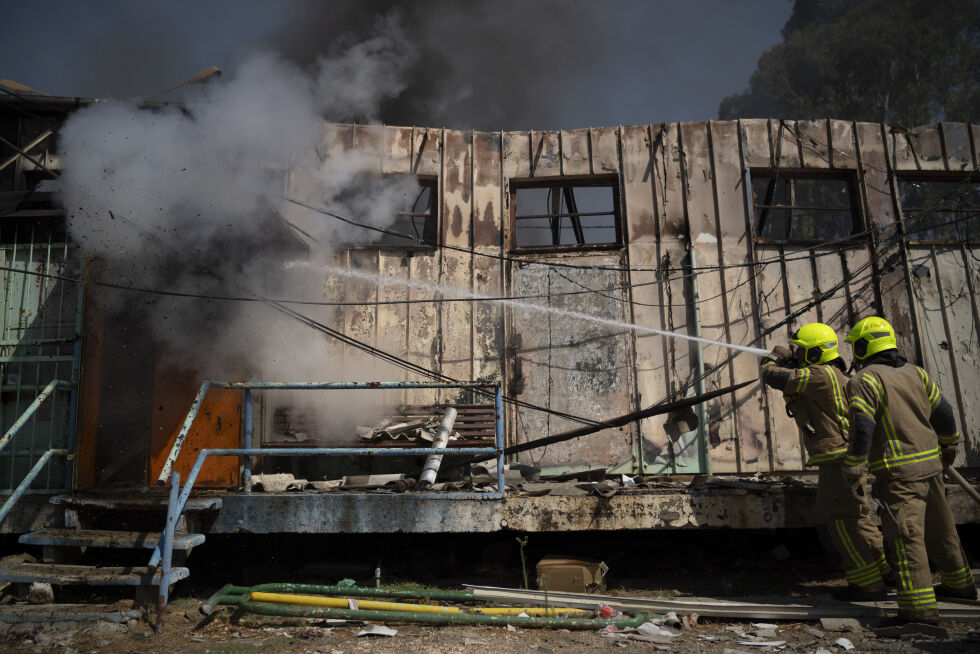 Brannmannskaper kjemper mot flammene etter at en rakett fra Libanon traff en bygning i Kiryat Shmona nord i Israel tirsdag.
 Foto: AP / NTB