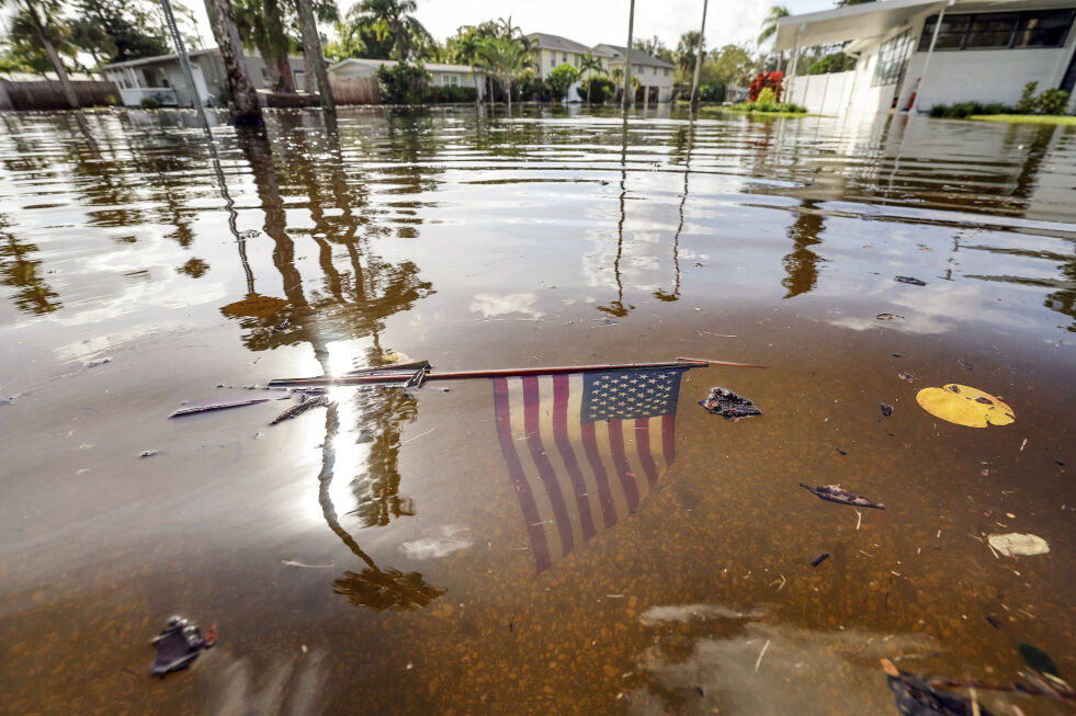 Et amerikansk flagg flyter i flomvannet fredag etter at Helene feide over Short Acres i St. Petersburg i Florida.
 Foto: Mike Carlson / AP / NTB