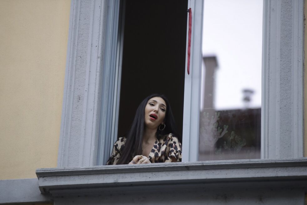 Operasanger Laura Baldassari synger fra vinduet i hjemmet sitt i Milano fredag 13. mars.
 Foto: Luca Bruno / NTB scanpix
