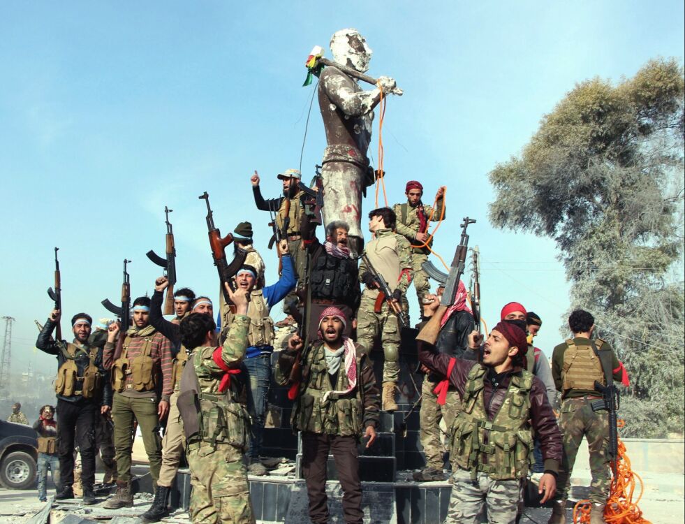 Syriske opprørere som er alliert med Tyrkia, feirer overtakelsen av Afrin by ved statuen av Kawa, en mytisk figur i kurdisk kultur, like før de går i gang med å rive den. Foto: AP / NTB scanpix