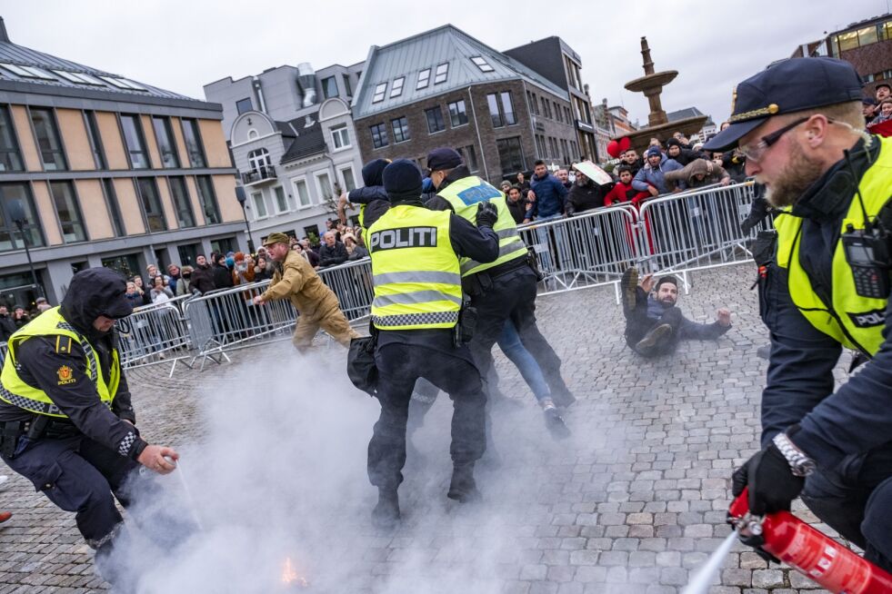 Politiet grep inn da SIAN-leder Lars Thorsen (i beige klær) tente på koranen i Kristiansand lørdag. Foto: Tor Erik Schrøder / NTB scanpix
