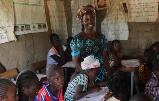 SAMARBEID: Strømmestiftelsen samarbeider med lokale skolemyndigheter for å kvalitetssikre Speed School. I landsbyen Binstigré utenfor hovedstaden Ouagadougou i Burkina Faso ser vi lærer Ilboudo Alizèta sammen med noen av elevene. FOTO: Egil Mongstad, Strømmestiftelsen.