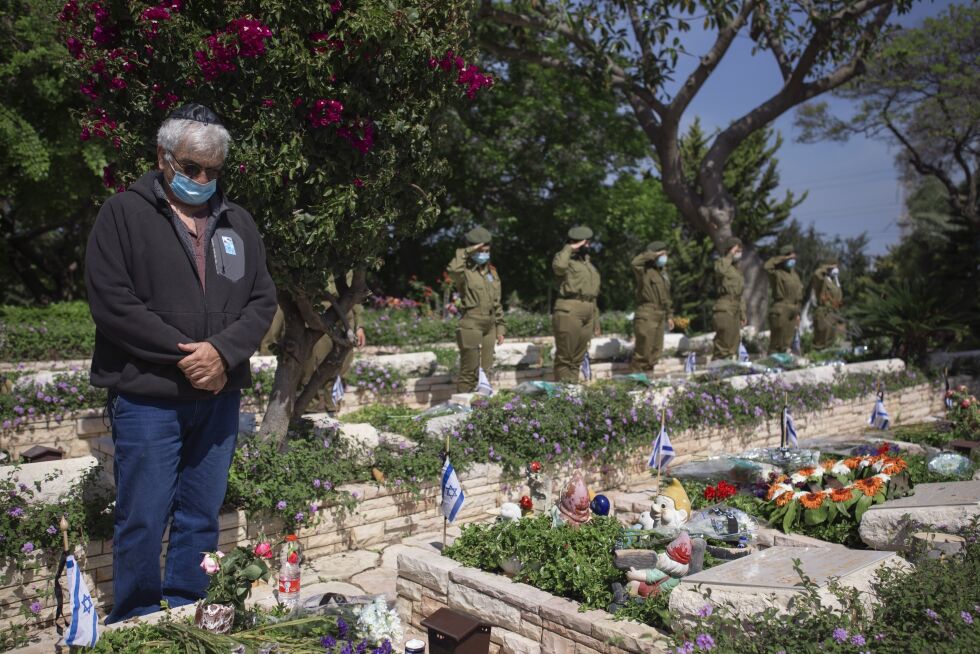 Et familiemedlem flankert av soldater fra det israelske forsvaret har en privat minnestund ved gravene til falne soldater i på Kiryat Shaul-militærgravstedet i Tel Aviv mandag.
 Foto: Oded Balilty/NTB Scanpix
