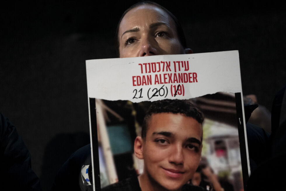 Yael Alexander holder opp en plakat med bildet av sønnen Edan Alexander, som ble tatt som gissel 7. oktober 2023, under en demonstrasjon i Tel Aviv i februar. Søndag sa Hamas at de vil slippe ham fri.
 Foto: Maya Alleruzzo / AP / NTB