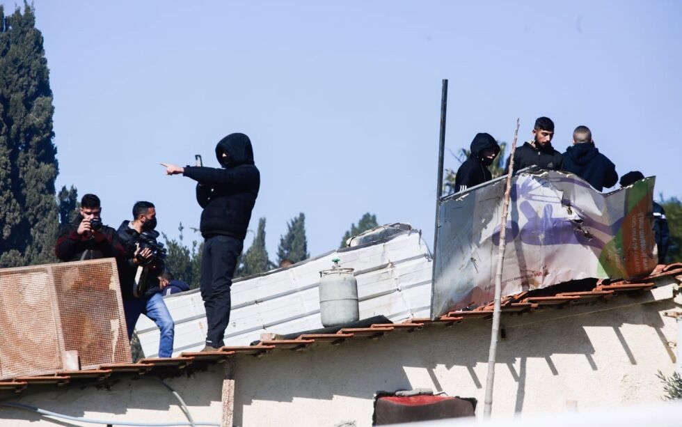 Husokkupantene klatret opp på taket og truet politiet med å sprenge seg selv i luften med en gassbeholder.
 Foto: Shalev Shalom/TPS