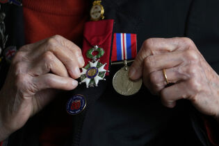 Tidligere «Wren» i det britiske militæret, Marie Scott, viser fram medaljene hun har fått for innsatsen under andre verdenskrig.
 Foto: Kirsty Wigglesworth / AP / NTB