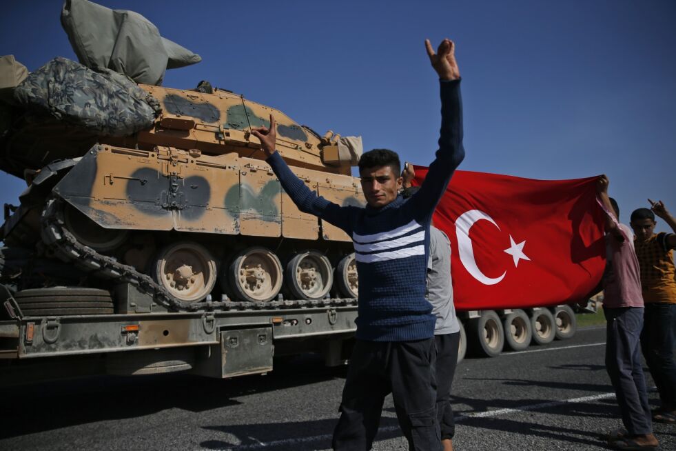 Tyrkia fortsetter sin militæroffensiv i Nord-Syria, der kurderne har bedt syriske regjeringsstyrker om å komme de til unnsetning. Her jubler tyrkere mens det kjøres stridsvogner inn i nabolandet. Foto: AP / NTB scanpix