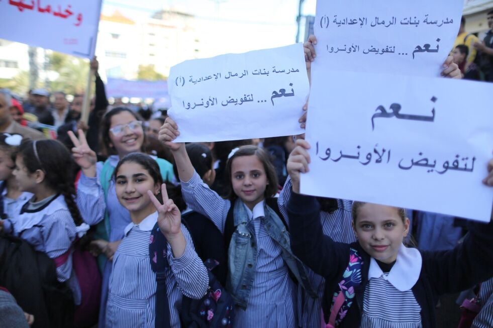 Barn på Gazastripen holder opp støtteplakater for UNRWA som er FNs hjelpeorganisasjon for palestinske flyktninger i Midtøsten. Organisasjonen bruker slike lærebøker som de britiske parlamentsmedlemmene reagerer så sterkt på.
 Foto: Majdi Fathi/TPS