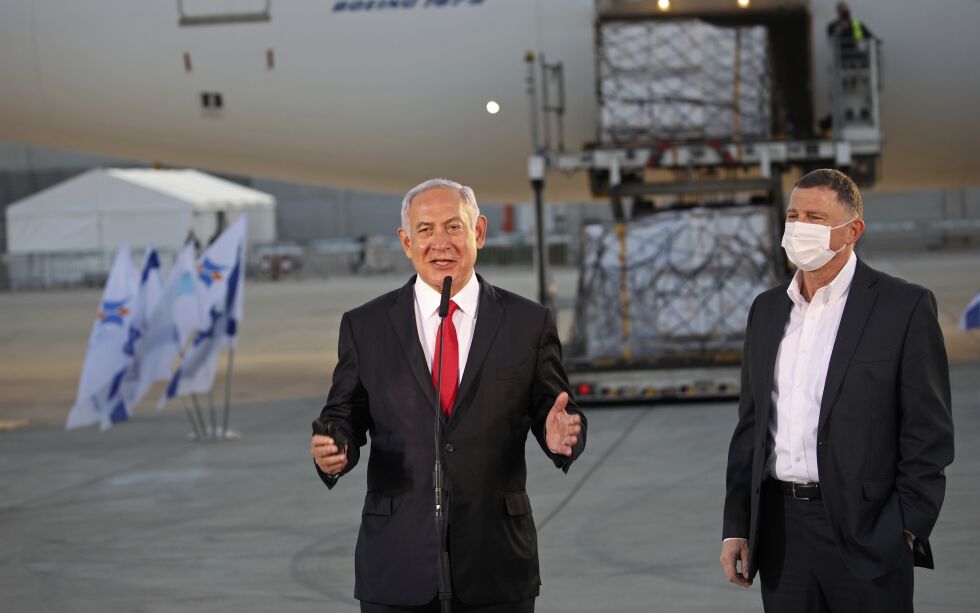 Israels statsminister Benjamin Netanyahu og helseminister Yuli Edelstein tar imot en last med vaksiner fra Pfizer på Ben Gurion lufthavn. De to har ordnet avtaler om vaksineleveranser fra både Pfizer og Moderna som skal rekke ut 2022.
 Foto: Motti Millrod / NTB