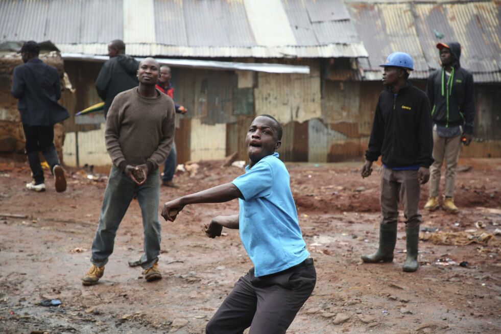 En tilhenger av opposisjonen kaster stein mot politiet i Kibera-slummen i Nairobi på valgdagen i Kenya. Foto: Brian Inganga / AP / NTB scanpix
