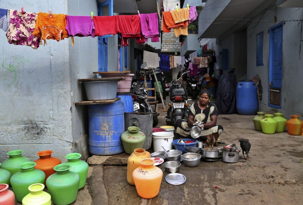 En kvinne vasker opp utenfor huset sitt i et fattig område i storbyen Bangalore i India. Illustrasjonsfoto: AP/NTB scanpix