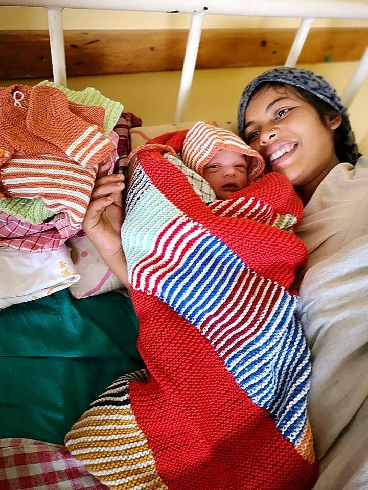 Nyfødt: Kvinne med sitt nyfødte barn inntullet i strikkede tepper fra Norge.
 Foto: Privat