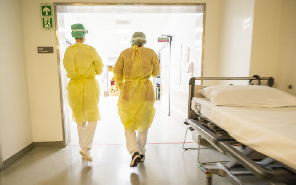 To sykepleiere kledd i smittevernutstyr går for å ta i mot en pasient med covid-symptomer på akuttmottaket på Ahus på Lørenskog i Viken.
 Foto: Håkon Mosvold Larsen / NTB