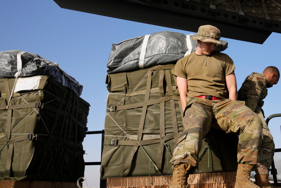 Medlemmer av det amerikanske luftvåpenet laster containere med humanitær hjelp langfredag ​, før de slipper dem over Gazastripen.
 Foto: NTB
