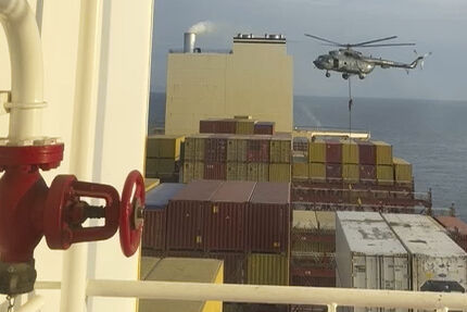 Et bilde fra en video som viser kommandosoldater som heises ned fra et helikopter til et konteinerskip i Omanbukta.
 Foto: AP / NTB
