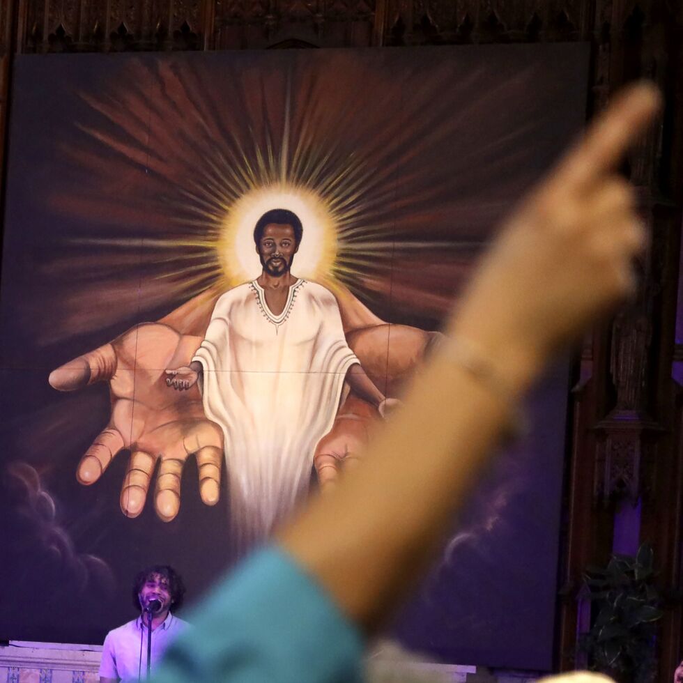 Et medlem rekker opp hånden foran et maleri av Black Jesus under en søndagsgudstjeneste i St. Sabina Catholic Church i Auburn Gresham-området i Chicago i 2021. Illustrasjonsbilde.
 Foto: Shafkat Anowar/Ap/NTB