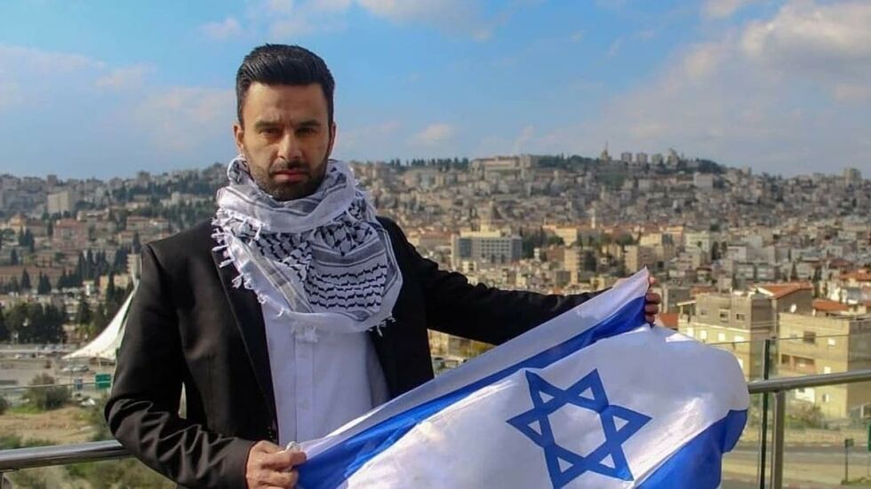 En av de fremste arabiske stemmene for Israel, Yoseph Haddad, kommer til arrangementet i Stavanger 14. mai, under feiringen av Israels 74-årsdag. På bildet holder Haddad det israelske flagget opp i sin hjemby Nasaret.