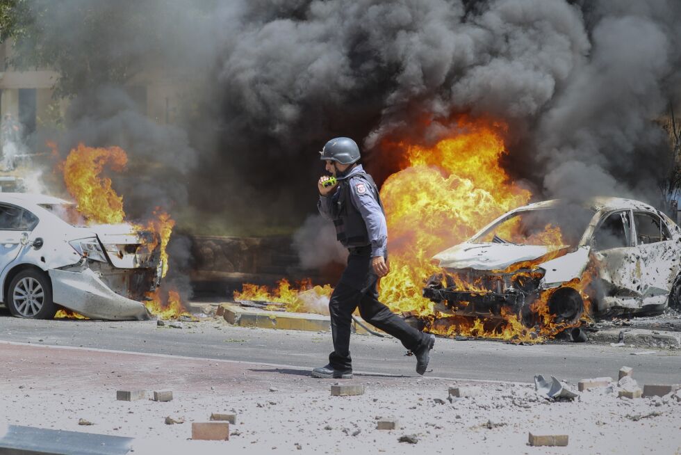 angrep fra Gaza: En brannmann i den israelske byen Ashkelon er kalt ut for å slukke bilbranner som er forårsaket av rakettangrep fra Gazastripen, tirsdag, 11. mai 2021.
 Foto: AP-foto/Ariel Schalit