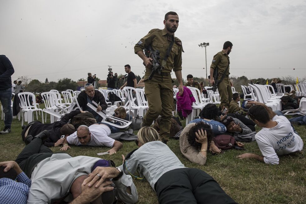 Israelere søker tilflukt idet sirenene varslet om rakettangrep fredag i kibbutzen Kfar Aza, der de var samlet for å markere bursdagen til den israelske soldaten Oron Shaul, som ble drept under den siste Gazakrigen. Foto: AP / NTB scanpix