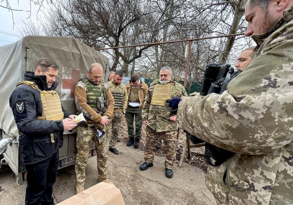 GUDSTJENESTE: Søndag tok assisterende generalsekretær Anatoliy Raychenets (tIl venstre) og styreleder Vasyl Lutsyshyn (midt i bildet) i Det Ukrainske Bibelselskapet seg helt fram til fronten for å betjene soldatene som kjemper der.
 Foto: Det Ukrainske Bibelselskapet.