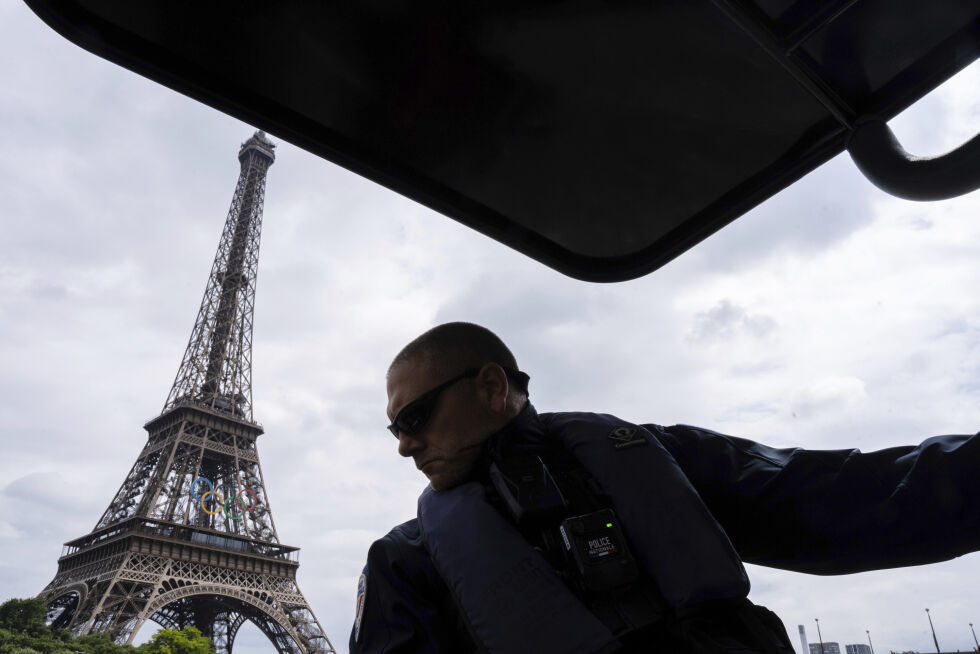 VED SEINEN: Politifolk patruljerer forbi Eiffeltårnet tirsdag 2. juli 2024 i Paris. Elven skal være vertskap for åpningsseremonien under de olympiske leker i Paris 2024.
 Foto: NTB/AP/Louise Delmotte