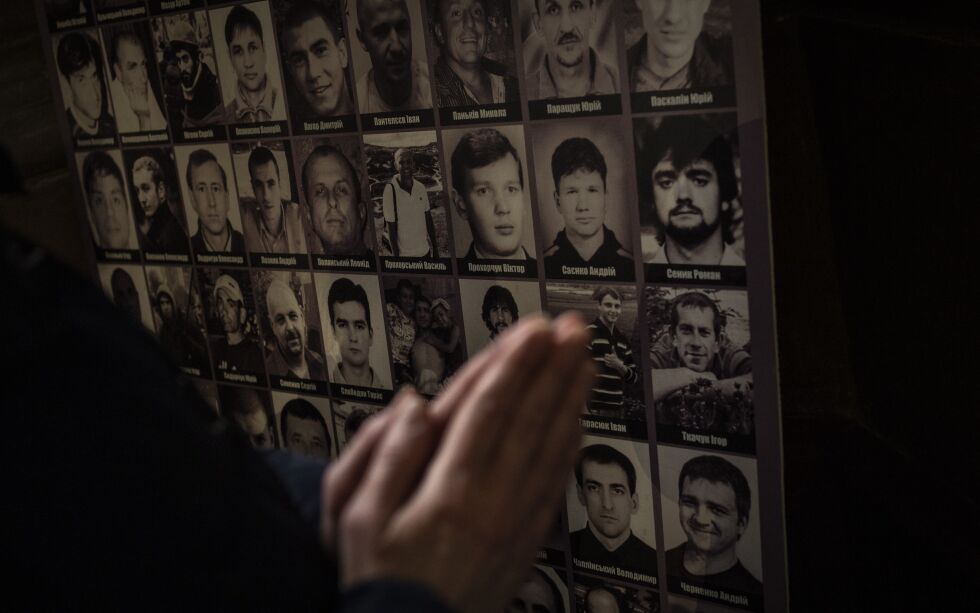 Bønn foran bilder av ukrainske soldater som har mistet livet siden 2014. Bildene henger i Saints Peter og Paul Garrison-kirken i byen Lviv, vest i Ukraina.
 Foto: Bernat Armanque / AP / NTB