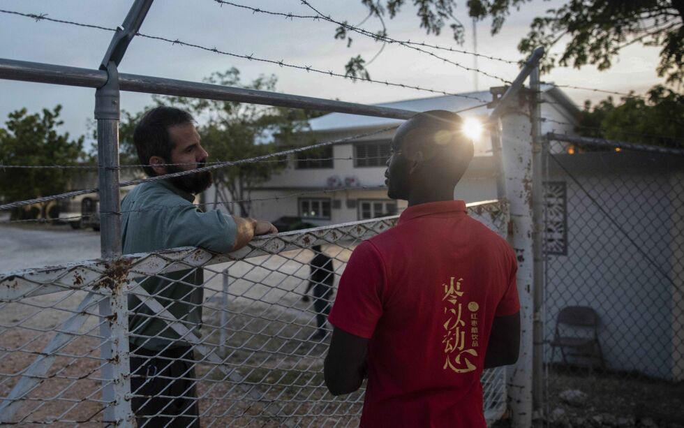 To ansatte snakker sammen ved hovedkvarteret til Christian Aid Ministries i byen Titanyen, nord for Port-au-Prince i Haiti. Nå er fem av de 17 nordamerikanske misjonærene som ble bortført, satt fri.
 Foto: Odelyn Joseph / NTB / AP