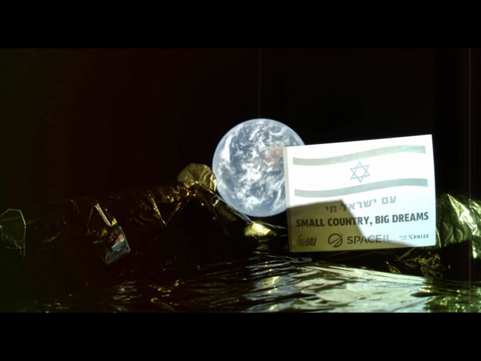 «Lite land, store drømmer», står det på plakaten som er festet på fartøyet Beresheet. Tirsdag sendte romfartøyet en selfie av seg selv der jorda kan ses i bakgrunnen. Foto: SpaceIL, Israel Aerospace Industries via AP / NTB scanpix