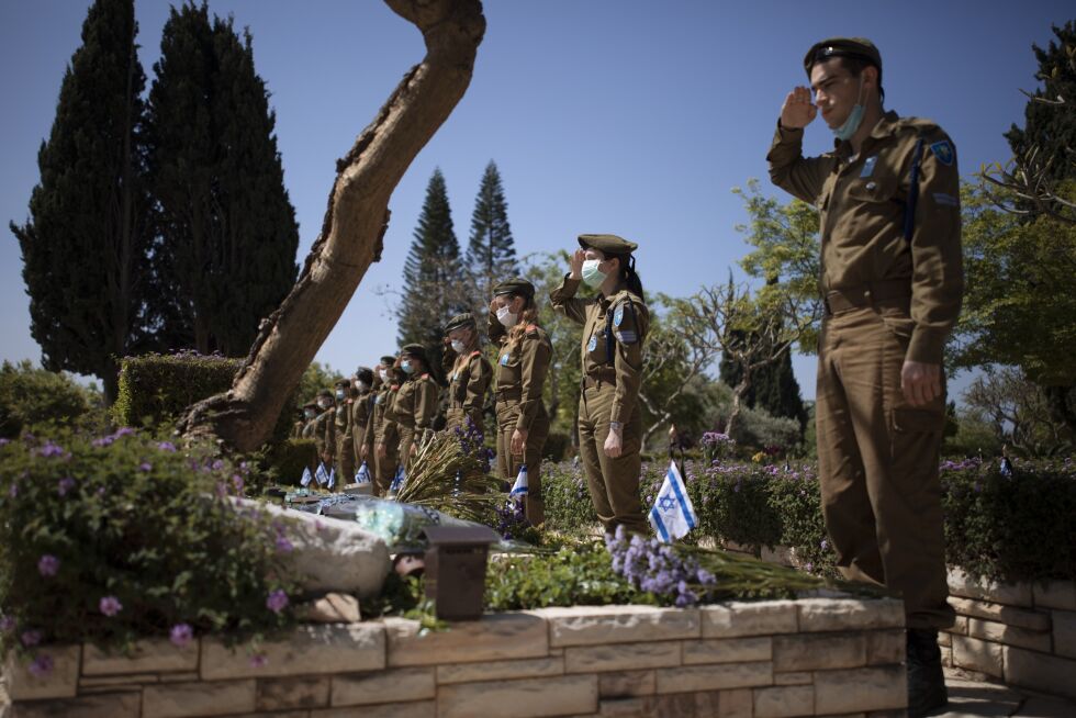 Israelske soldater med munnbind står ved siden av falne soldaters graver på Kiryat Shaul-militærgravstedet i Tel Aviv mandag.
 Foto: Oded Balilty / AP / NTB scanpix