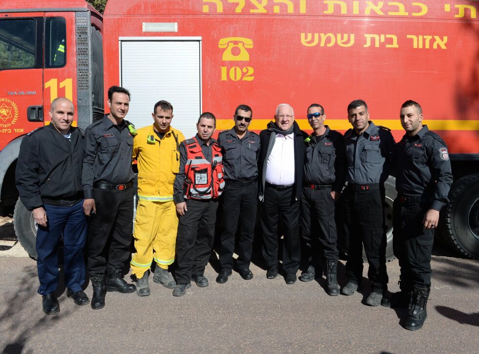 Israels president Reuven Rivlin saman med nokre av pilotane som har sløkt brannane i Israel.
 Foto: Ashernet