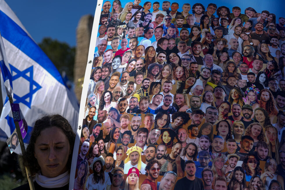 ISRAEL: En kvinne utenfor Knesset med det israelske flagget og bilder av gislene som ble bortført av Hamas 7. oktober i fjor.
 Foto: NTB/AP/Ariel Schalit