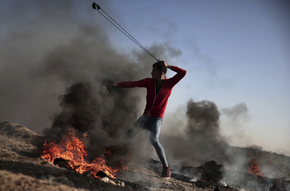 ANGRIPER: Mange av demonstrantene var voldelige. Her kaster en av dem stein mot israelerne på andre siden av grensen. Foto: AP / NTB Scanpix
