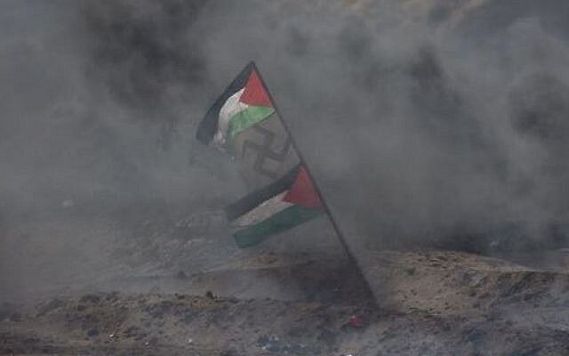 Gaza-grensen fredag 6. april. Et hakekors vaier mellom to palestinske flagg i røyken fra brennende bildekk.
 Foto: IDF