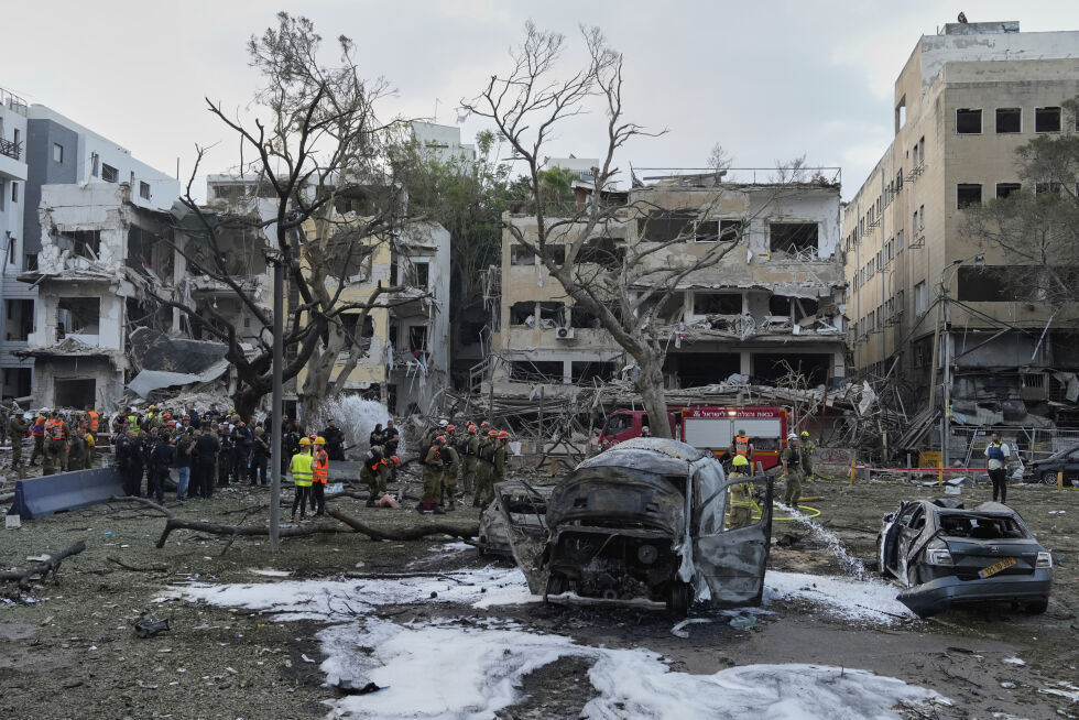 Redningsarbeidere jobber mandag morgen på stedet der en iransk rakett slo ned i Tel Aviv.
 Foto: Baz Ratner / AP / NTB